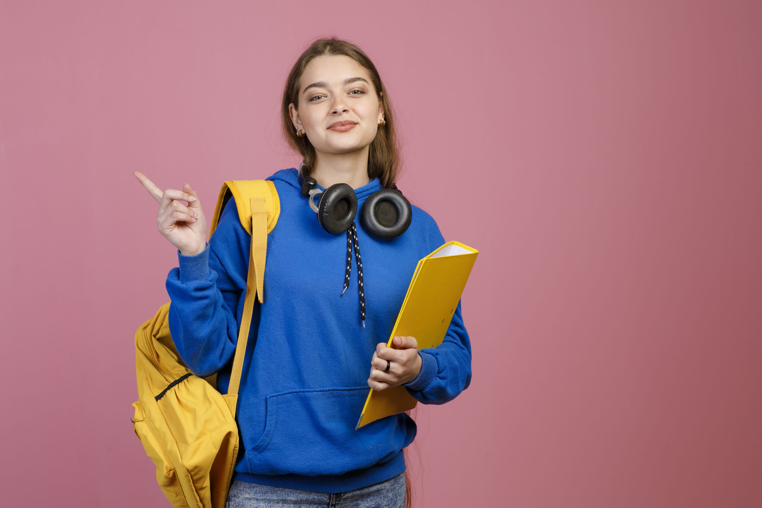 Pretty brunette female standing, pointing by finger. Student die prestatiedruk ervaart